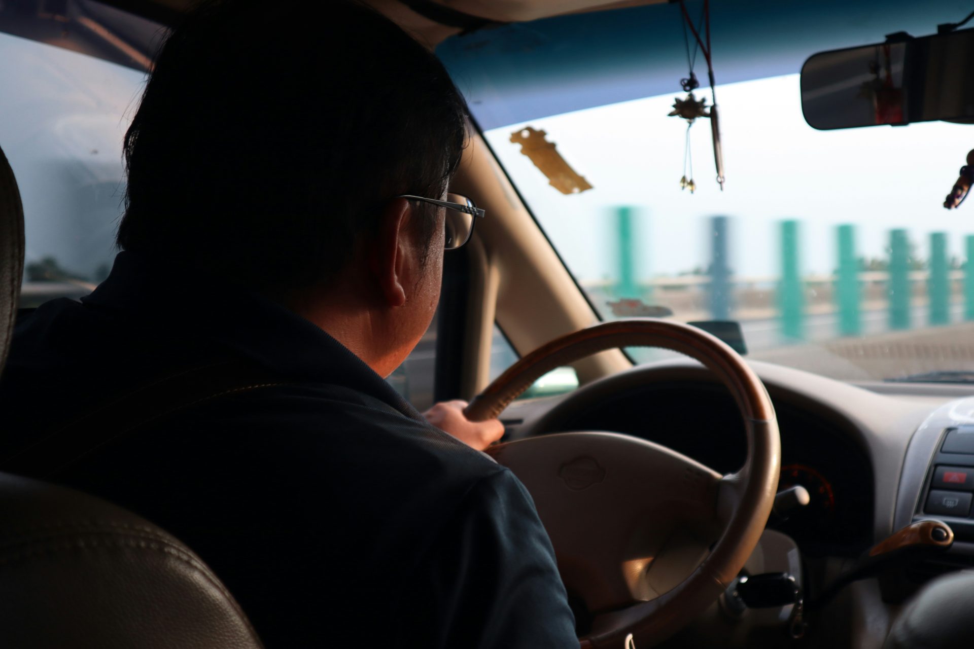 man in black shirt driving car during daytime