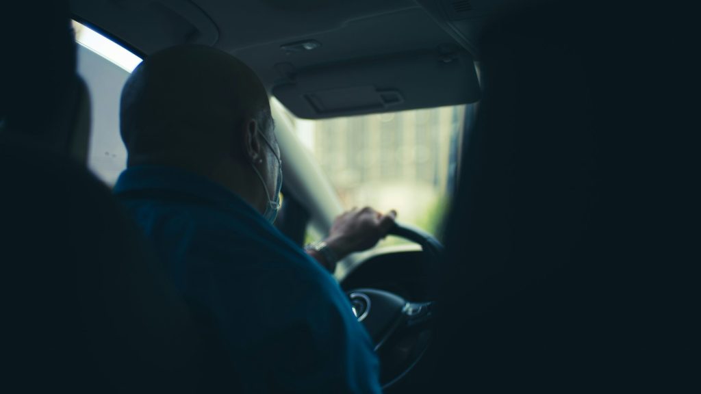 man in blue shirt driving car