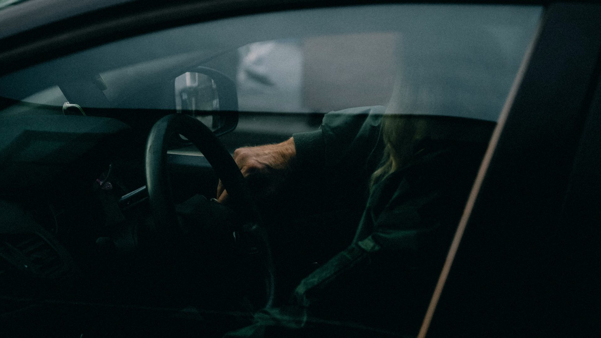 a woman driving a car in the dark